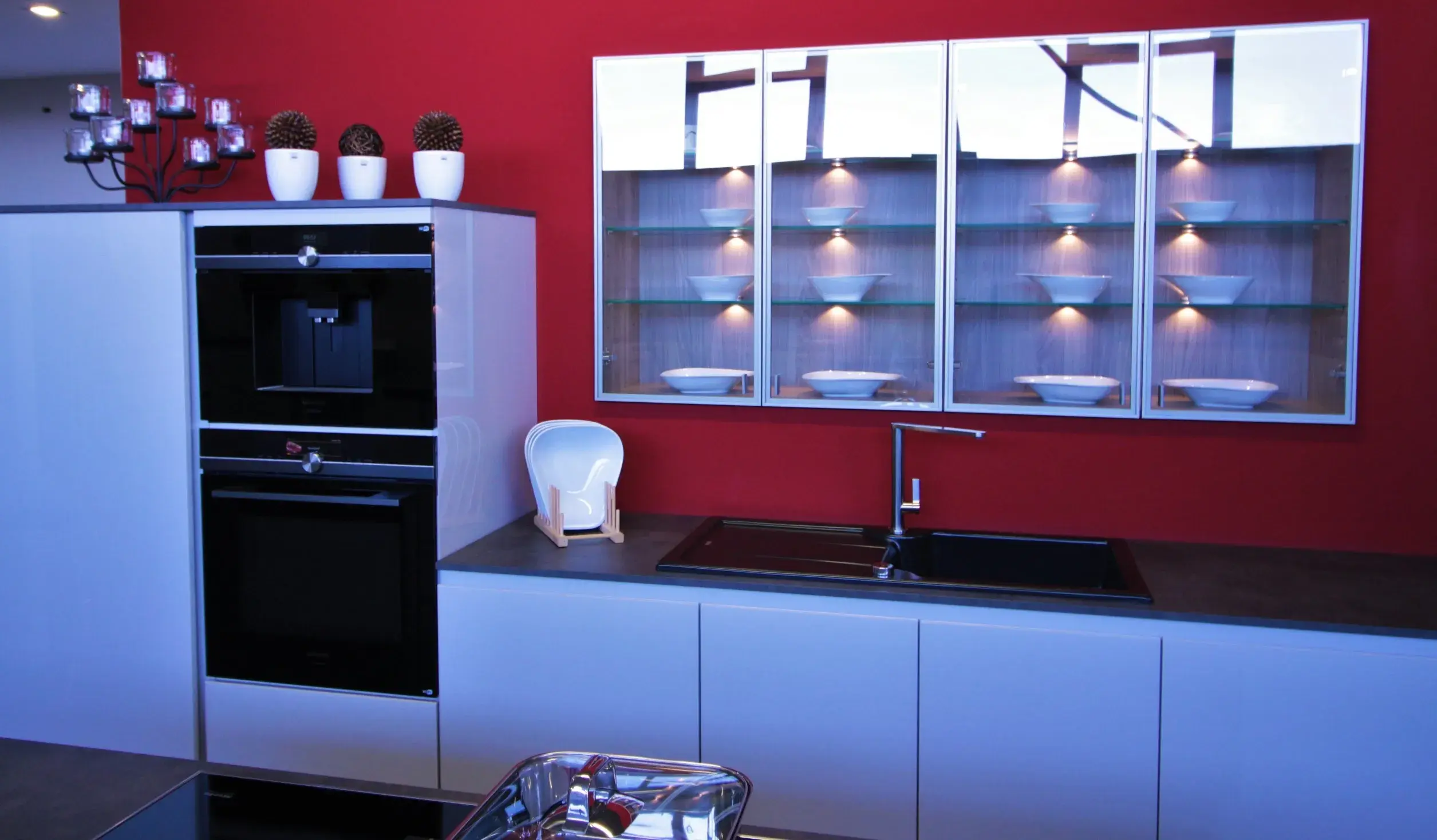 Front einer weißen Küche mit dunkler Arbeitsplatte