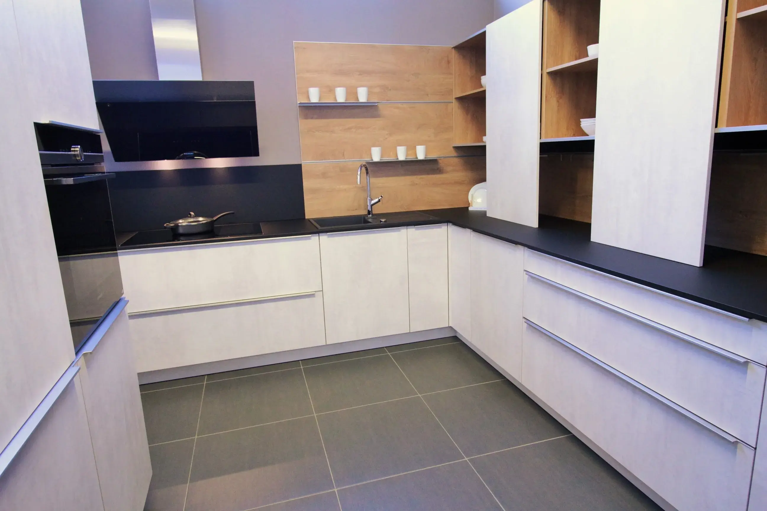 Weiß-schwarze Küche mit hellen Küchenfronten und schwarzer Arbeitsfläche