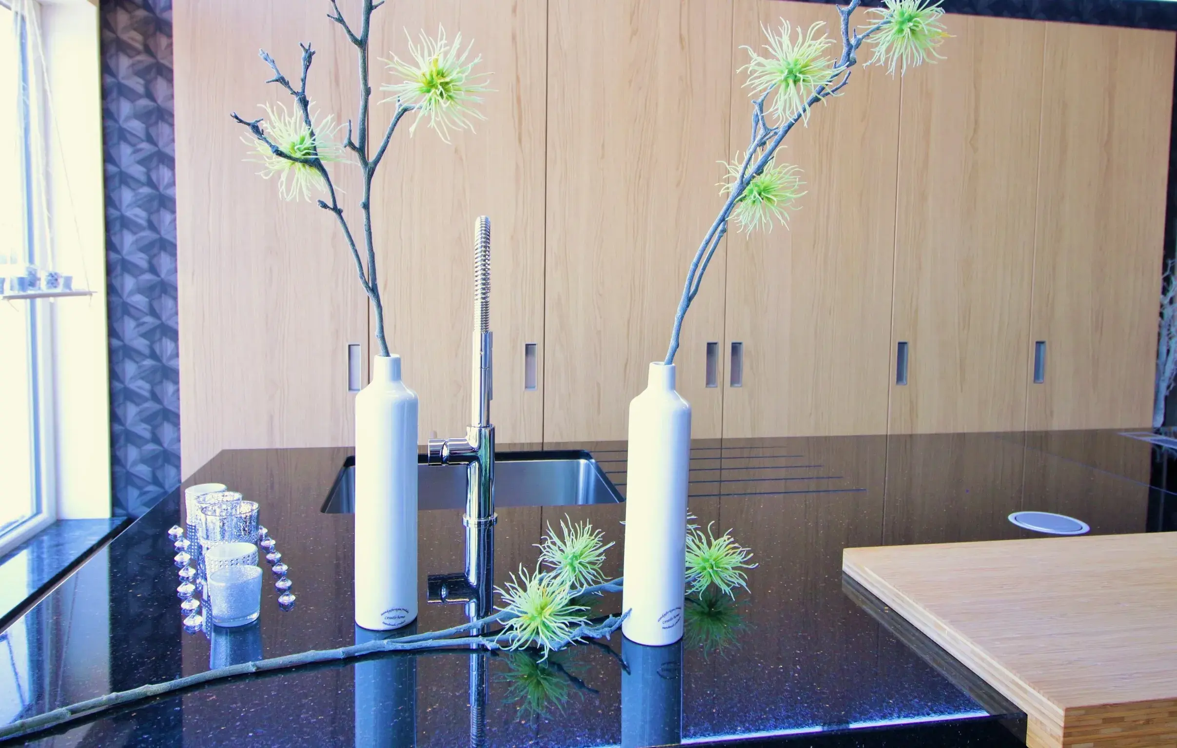 Küche mit dunkler Arbeitsfläche und heller Holzfront 