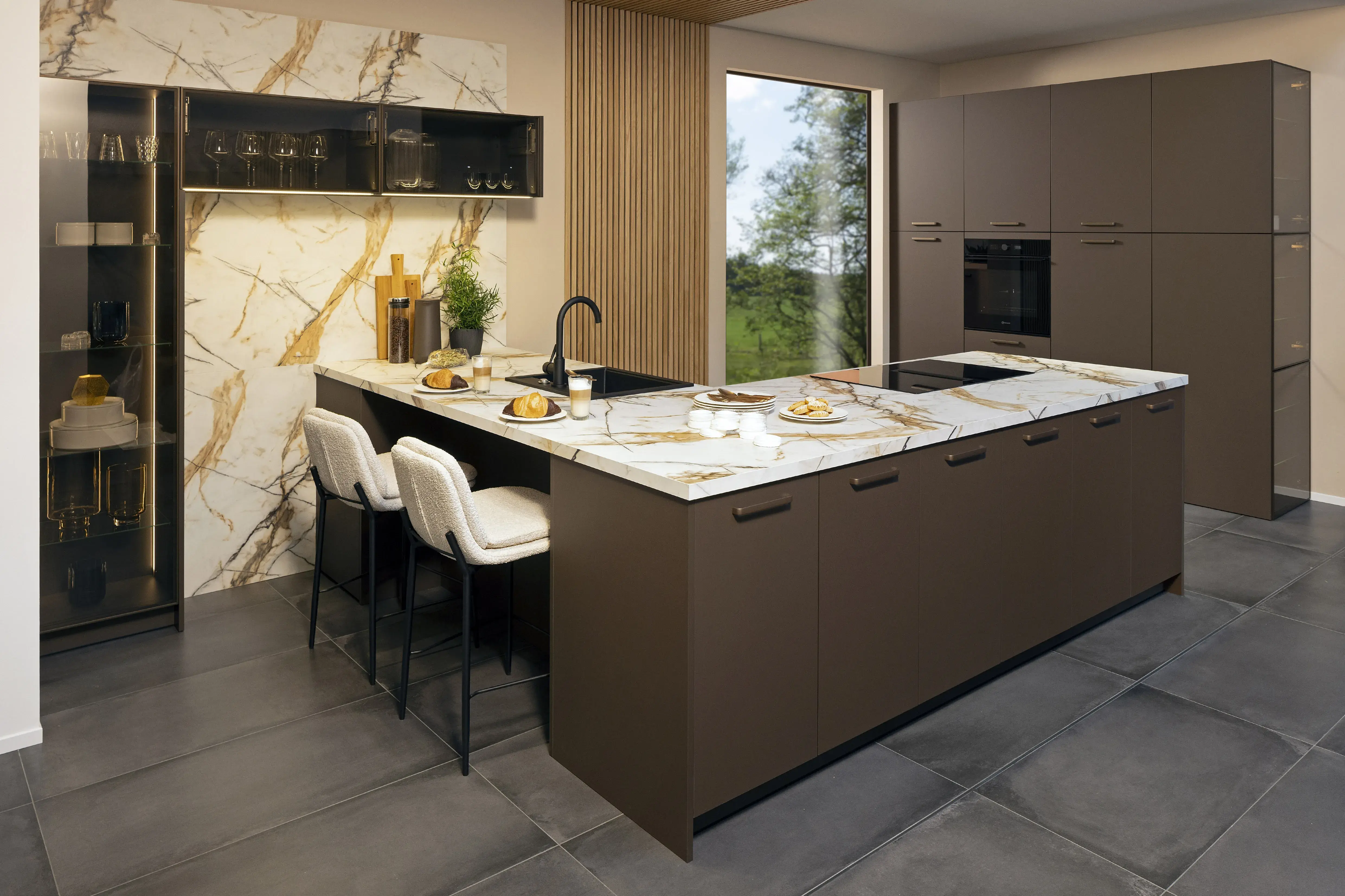 Moderne Küche mit Kochinsel, Marmorarbeitsplatte und zwei weißen Barhockern.